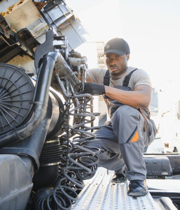 African american Professional Truck Mechanic Rebuilding Heavy Duty Truck Diesel Engine. Automotive Industry Theme.