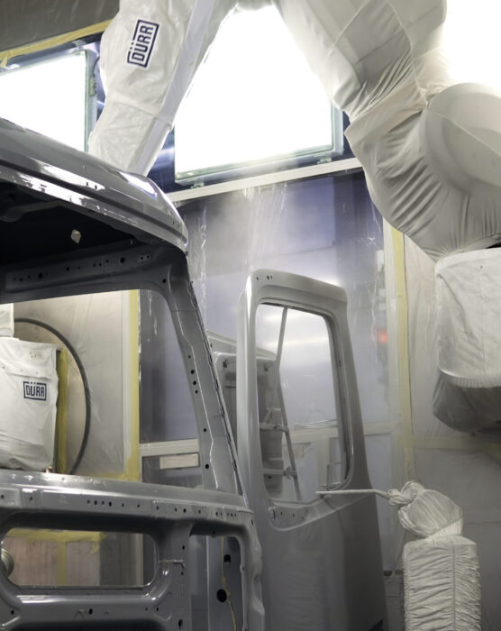 Assembly and disassembly of passenger cars. Scene . The disassembled parts of the car are made in the salon where the man works, twisting the doors and trying to fix them