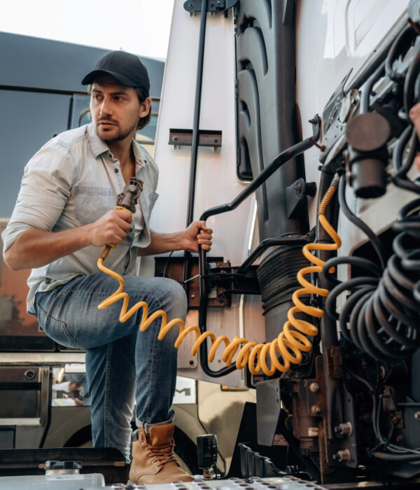 Messing with cables, installation, fix. Truck driver is near the transport outdoors.