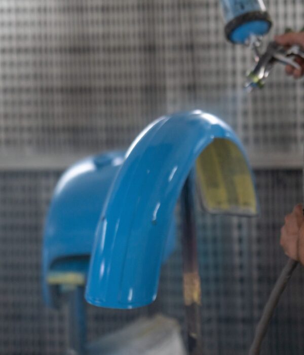 A specialist using spray gun for painting car details